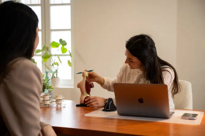 Chiropracteur expliquant la colonne vertébrale à une patiente à Verfeil